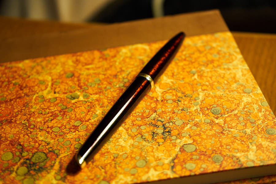 stylo plume sur cahier marbré de papeterie florentine