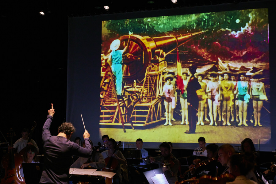 Benjamin Levy dirige l’Orchestre National de Cannes en ciné-concert dans la partition d’Alexis Savelief sur le film de Georges Méliès “Le Voyage dans la Lune”, ici la scène où le canon s’apprête à envoyer sur la Lune la capsule spatiale…