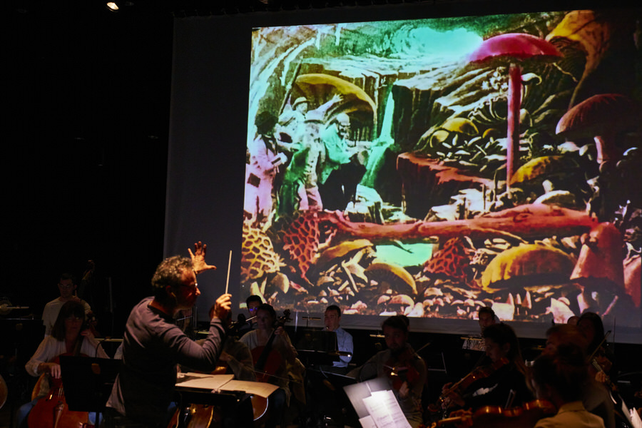 Benjamin Levy dirige l’Orchestre National de Cannes en ciné-concert dans la partition d’Alexis Savelief sur le film de Georges Méliès “Le Voyage dans la Lune”, ici la scène où nos astronomes-astronautes découvrent le monde sous-terrain de la Lune…